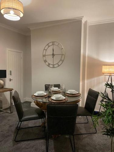 a dining room with a table and a clock on the wall at Stylish 3 Bed Home in Clitheroe in Clitheroe