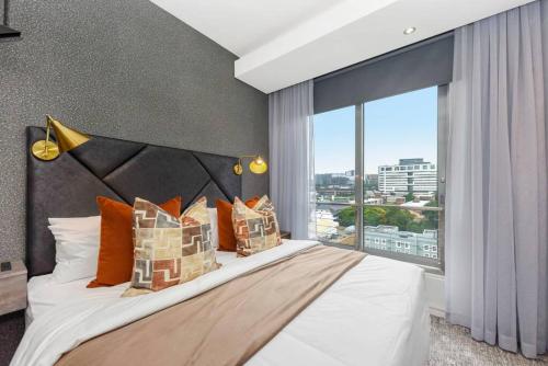 a bedroom with a large bed with a large window at Stylish Apartment in a 5 star hotel in Johannesburg