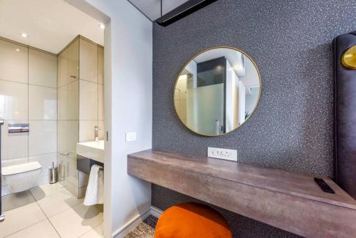 a bathroom with a mirror and a sink at Stylish Apartment in a 5 star hotel in Johannesburg