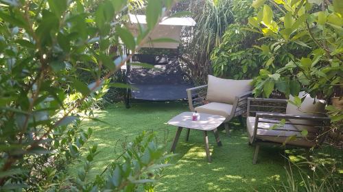 a garden with two chairs and a table in the grass at Nichochot Provence in Had Nes
