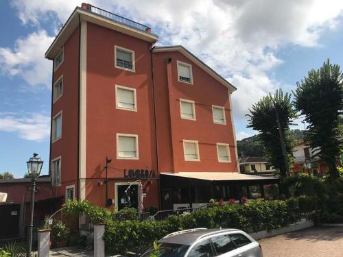 a red building with a car parked in front of it at Locanda L'Ombrosa in Vezzano Ligure
