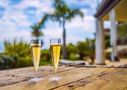 two glasses of champagne sitting on a wooden table at Villa Zagara Garden Spectacular Sea View in Taormina in Taormina