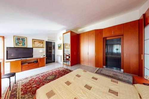 a bedroom with a bed and a flat screen tv at Villa con piscina e giardino a due passi dal mare. in Su Forti