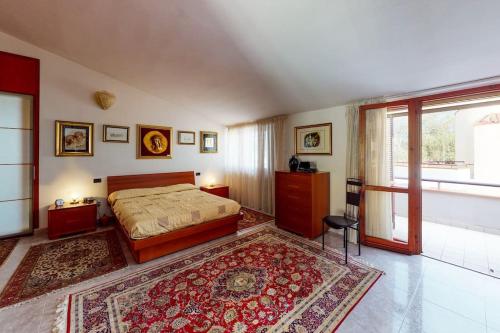 a bedroom with a bed and a large rug at Villa con piscina e giardino a due passi dal mare. in Su Forti