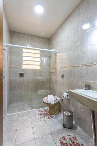 a bathroom with a shower and a toilet and a sink at Pousada Jardon Campos do Jordão - Exclusiva para Adultos in Campos do Jordão