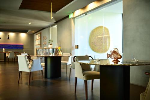 a restaurant with white chairs and tables and a window at Hotel Royal Paestum in Paestum
