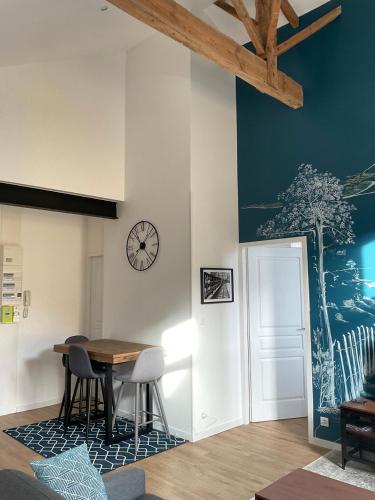 une salle à manger avec une table et une horloge au mur dans l'établissement T2 stylé/calme et confortable, à Arcachon
