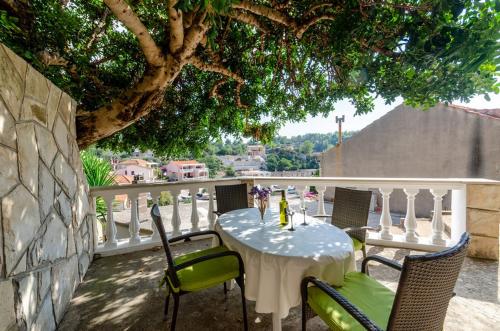 una mesa y sillas en un balcón con un árbol en Apartments Katica's Place, en Prizba