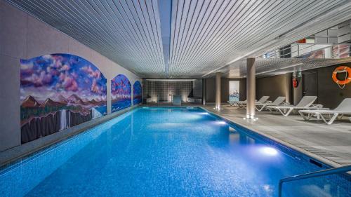 - une grande piscine d'eau bleue dans un bâtiment dans l'établissement Roc Blanc Hotel & Spa, à Andorre-la-Vieille
