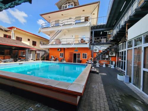 a swimming pool in front of a building at Hotel Bar Restaurant Emergency 911 STO LK GROUP in Paramaribo