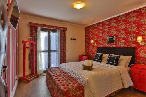 a bedroom with a large bed and red wallpaper at Pousada Jardon Campos do Jordão - Exclusiva para Adultos in Campos do Jordão