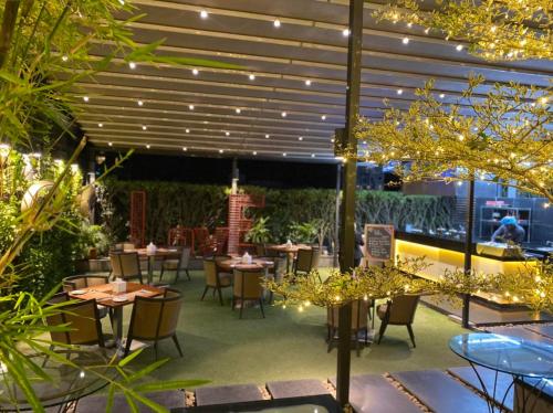 a restaurant with tables and chairs and lights at Crowne Plaza Dhaka Gulshan by IHG in Dhaka