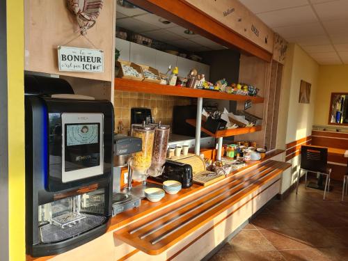 a counter in a restaurant with a cash register at Hôtel Akena City Caudry in Caudry