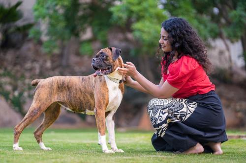 a woman is petting a brown and white dog at Hyatt Hyderabad Gachibowli in Hyderabad