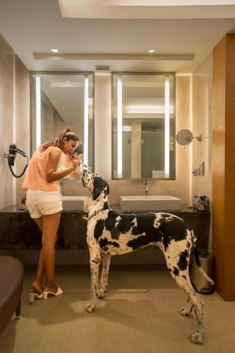 a woman brushing a dog in a bathroom at Hyatt Hyderabad Gachibowli in Hyderabad