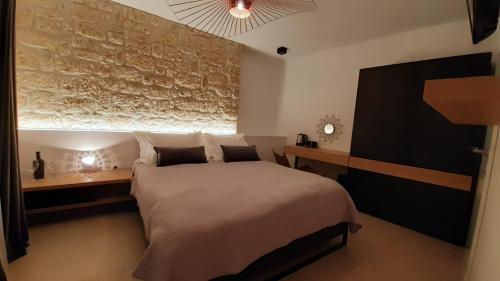 um quarto com uma cama grande e uma parede de pedra em ST. CLARA OLD TOWN em Sibenik