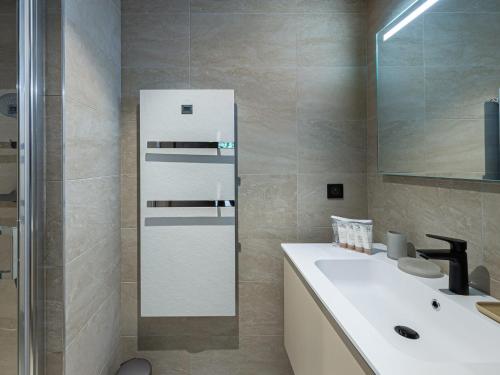 une salle de bain avec un lavabo blanc et un miroir dans l'établissement Charmant appartement à Rochebrune avec jardin pour 6 personnes – Accès piscine, salle de sport, sauna - FR-1-569-24, à Megève