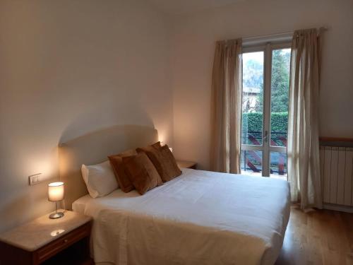 a bedroom with a white bed and a window at Presolana Home in Castione della Presolana