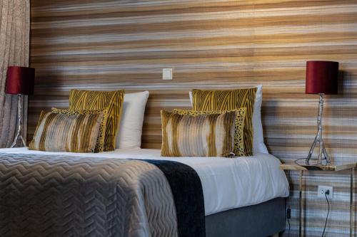 a bedroom with a bed with a wooden wall at Boutique Hotel Slenaker Vallei - Buitengewoongenieten in Slenaken