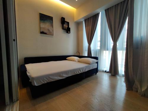 Un dormitorio con una cama en una habitación con ventanas. en Star Suite 5min Walk to KLCC Netflix, en Kuala Lumpur