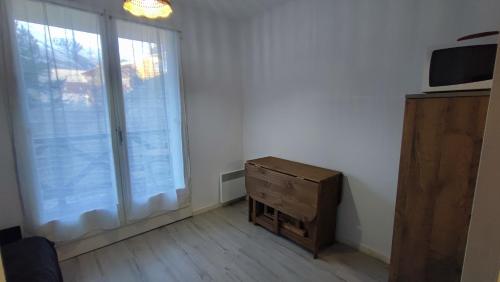 a room with a dresser and a large window at La Foux d'Allos - Studio 4 pers. in Allos