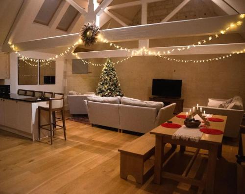 a living room with a christmas tree in it at The Old Library in Painswick