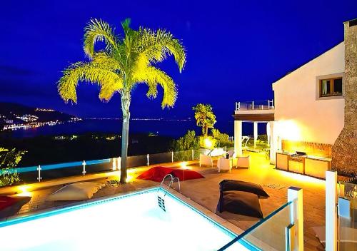 a house with a palm tree and a swimming pool at Villa Zagara Garden Spectacular Sea View in Taormina in Taormina