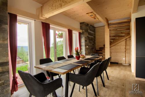 a dining room with a long table and chairs at Domek u Justyny in Kościelisko