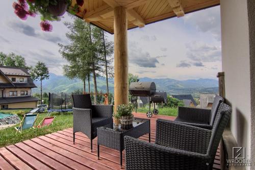 a deck with chairs and a table with a view at Domek u Justyny in Kościelisko