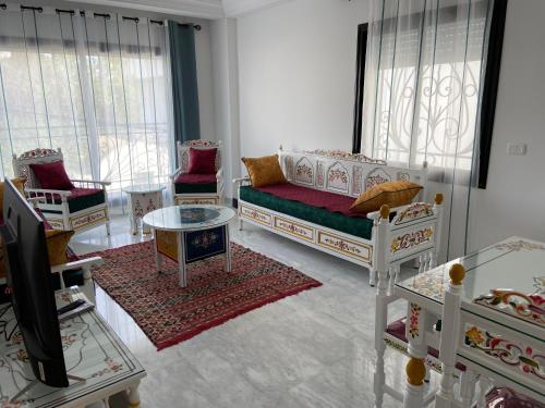 - un salon avec un canapé, des chaises et une télévision dans l'établissement Marsa Authentic Luxury Appart 1, à La Marsa
