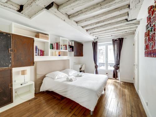 a bedroom with a white bed and wooden floors at Confortable appartement pour 4 pers à Paris by Weekome in Paris