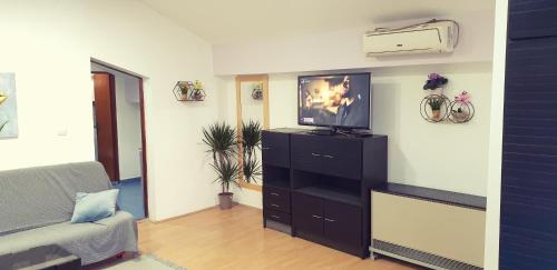 a living room with a couch and a television on a dresser at City center apartment 3 in Niš