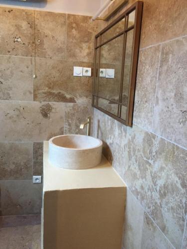 een badkamer met een wastafel en een spiegel bij Maison au bord de mer in Saintes-Maries-de-la-Mer
