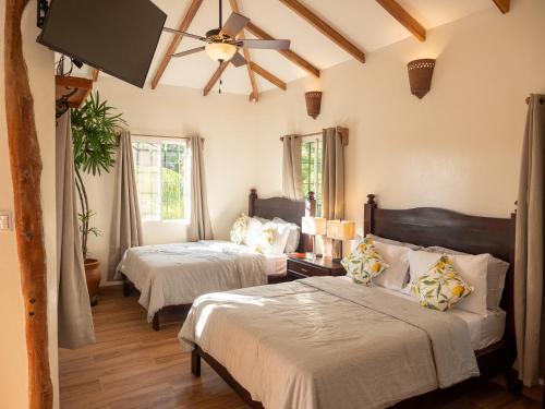 a bedroom with two beds and a ceiling fan at Nicawaves in Popoyo