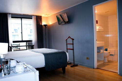 Tempo Rent Apart Hotel في سانتياغو: غرفه فندقيه بسرير وحمام
