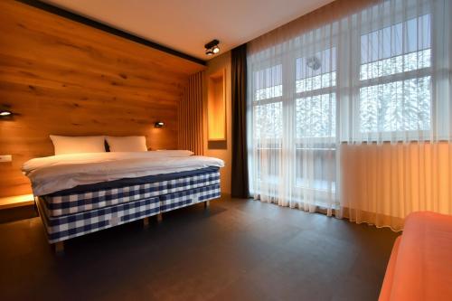 een slaapkamer met een bed en een groot raam bij Apartment next to the slopes in St. Peter in Špindlerův Mlýn