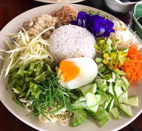 einen Teller mit Reis und Gemüse auf dem Tisch in der Unterkunft Saline Hot Spring Resort นำ้พุร้อนเค็ม รีสอร์ท in Ban Nam Ron (1)