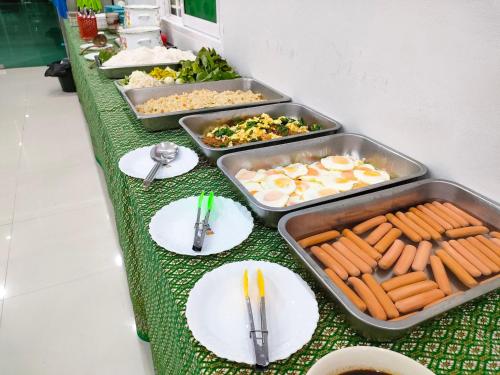 ein Buffet mit Tellern voller Essen auf einem Tisch in der Unterkunft Saline Hot Spring Resort นำ้พุร้อนเค็ม รีสอร์ท in Ban Nam Ron (1)