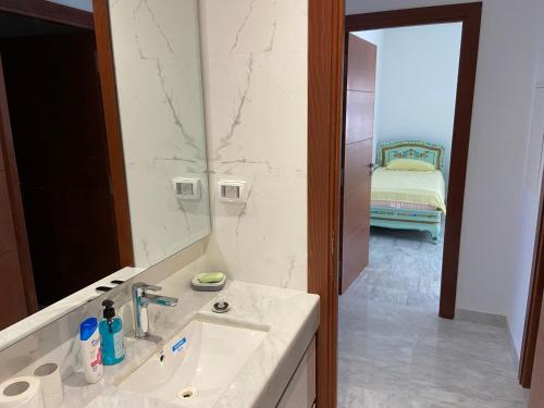 W łazience znajduje się umywalka i lustro. w obiekcie Marsa Authentic Luxury Appart 1 w mieście La Marsa
