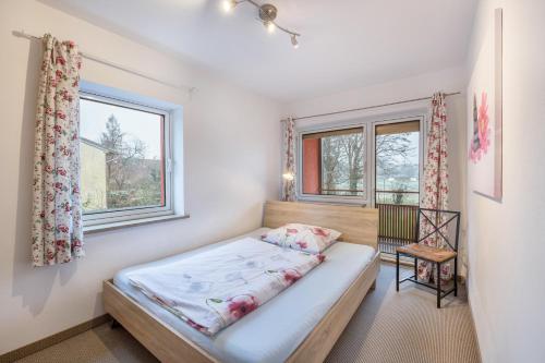 a bedroom with a bed and two windows at Haus Rose Muc City in Munich