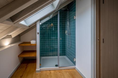 a bathroom with a shower with green tile at Villa Galega in Silveira