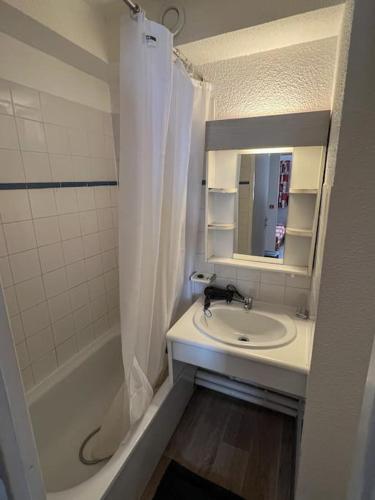 une salle de bain avec un lavabo, une douche et un miroir dans l'établissement Altineige Center village, à Val Thorens