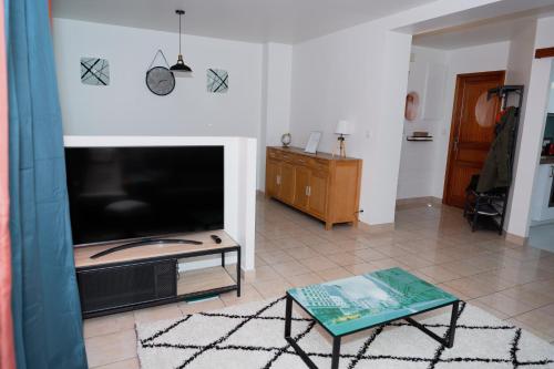 a living room with a large flat screen tv at KASA JURA - Au coeur des monts in Saint-Claude