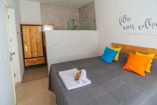 a bedroom with a bed with colorful pillows at Amwilla Guesthouse Apartamento Elsa in Mindelo