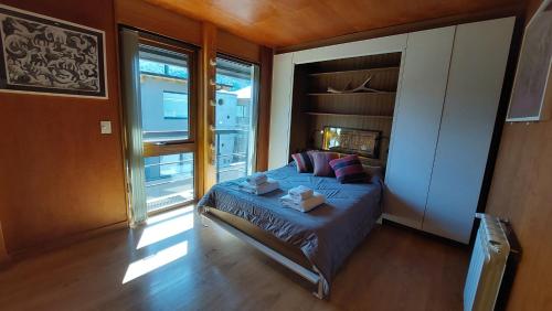 a bedroom with a bed and a large window at Departamento 3 ambientes súper cálido, en el centro de SMA. 19V4 in San Martín de los Andes