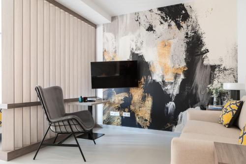 un soggiorno con sedia e TV a parete di Apartamentos Las Torres a Madrid