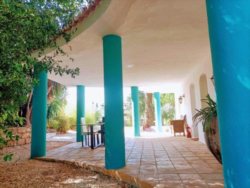 an outdoor patio with blue columns and a table at Tottam Art & Healthy Garden in Málaga