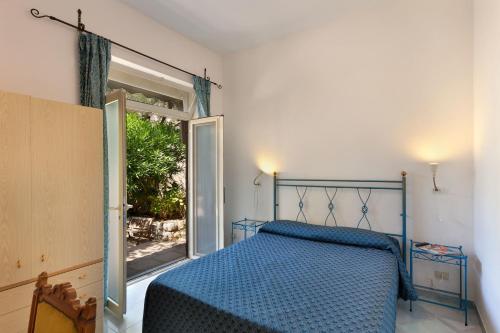a bedroom with a blue bed and an open door at Villaggio Villa Lubrense in Massa Lubrense