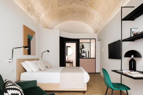 une chambre avec un lit blanc et une chaise verte dans l'établissement Mirabilis Relais, à Naples
