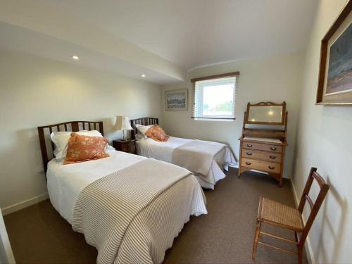 1 Schlafzimmer mit 2 Betten, einer Kommode und einem TV in der Unterkunft Stable Cottage in Sandwich